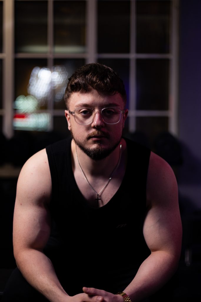 Authentisches Fitnessporträt in industrieller Umgebung mit kreativer Lichtsetzung.