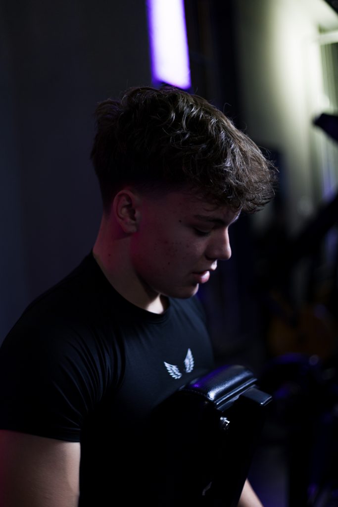 Authentisches Fitnessporträt in industrieller Umgebung mit kreativer Lichtsetzung.