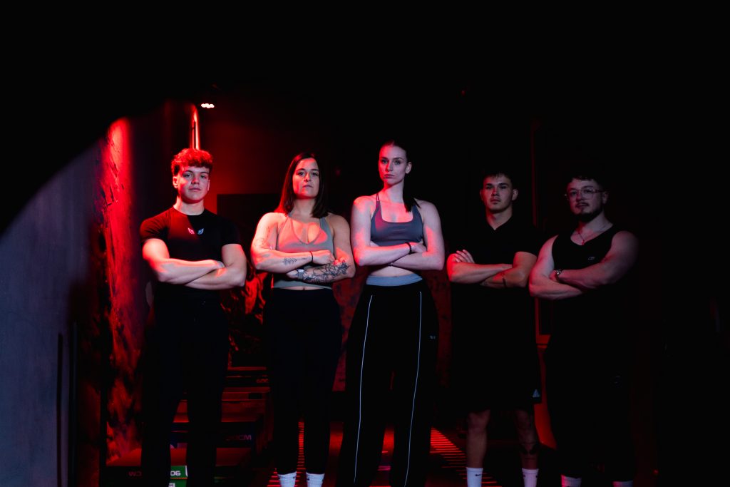 Authentisches Fitnessporträt in industrieller Umgebung mit kreativer Lichtsetzung.