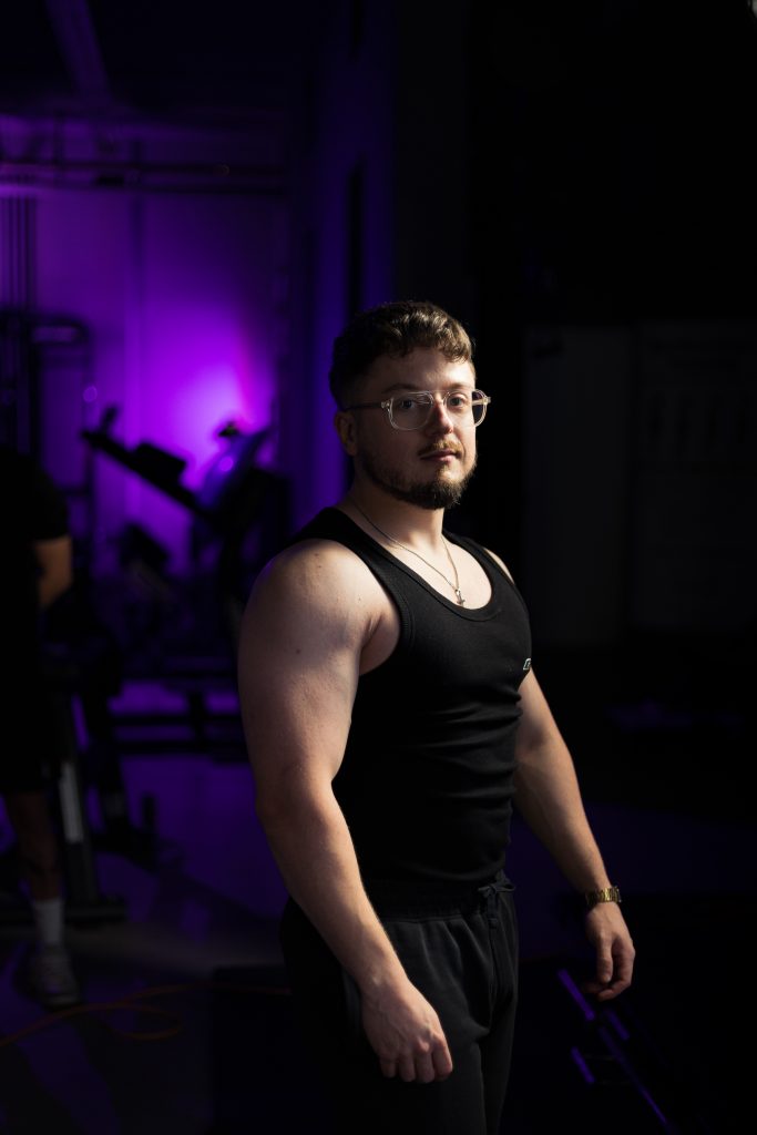 Authentisches Fitnessporträt in industrieller Umgebung mit kreativer Lichtsetzung.